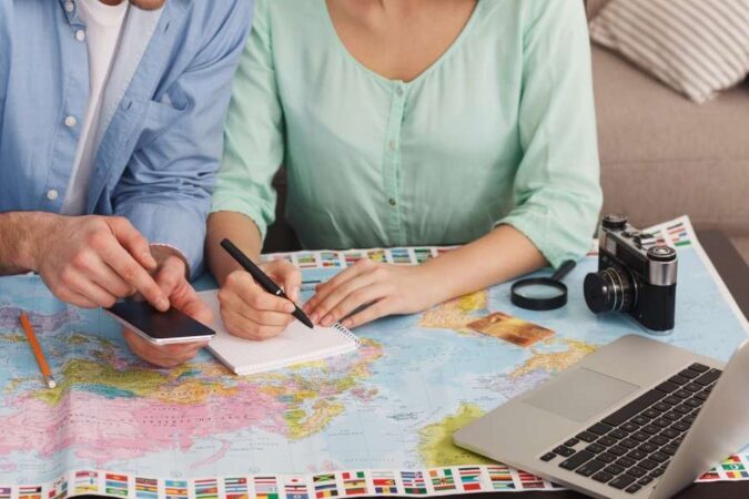 Un couple planifie ses prochaines vacances en consultant une carte, loin des mythes sur les voyages organisés.