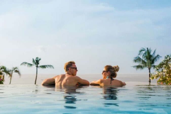 Un couple profite d'une vue imprenable depuis une piscine à débordement lors d'un séjour en station thermale.