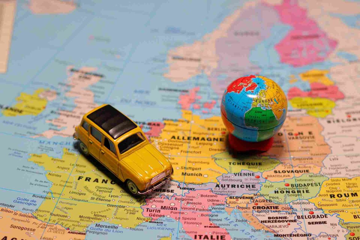 Une carte routière d'Europe avec une voiture miniature jaune et un petit globe terrestre dessus, illustrant comment adapter le rythme de son voyage.