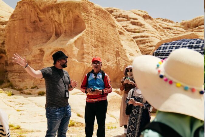 Un guide local explique l'histoire d'un site naturel désertique à un groupe de touristes